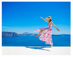 happy woman pretty dress and hat jumping in the air
