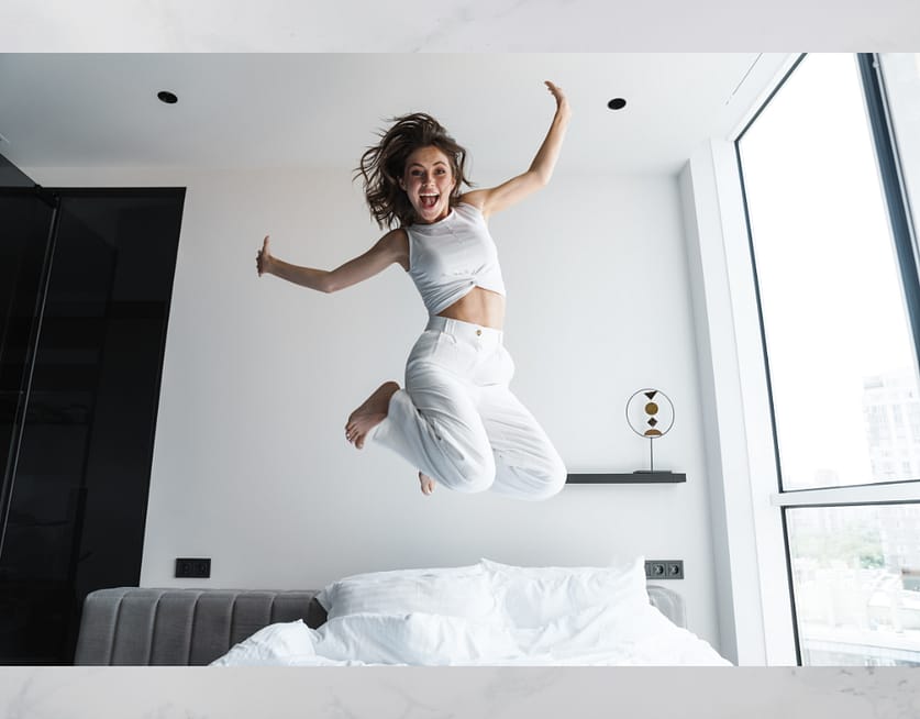 woman jumping out of bed with energy