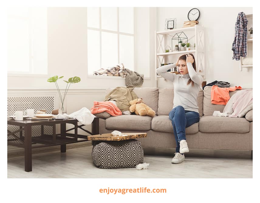 woman sitting on sofa in a messy house