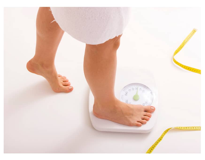 woman stepping on weighing scales