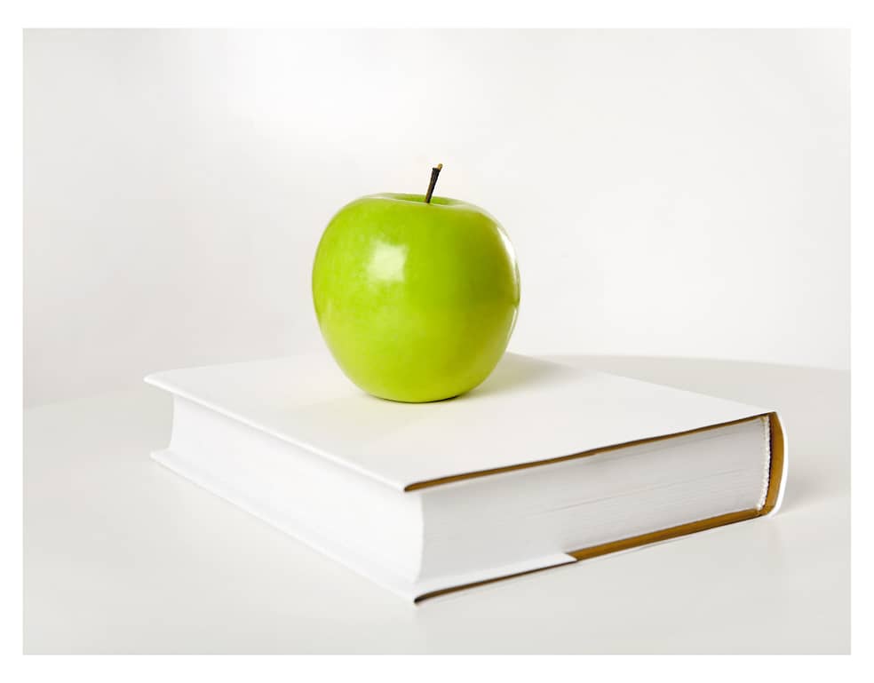 book with apple sitting on top healthy eating